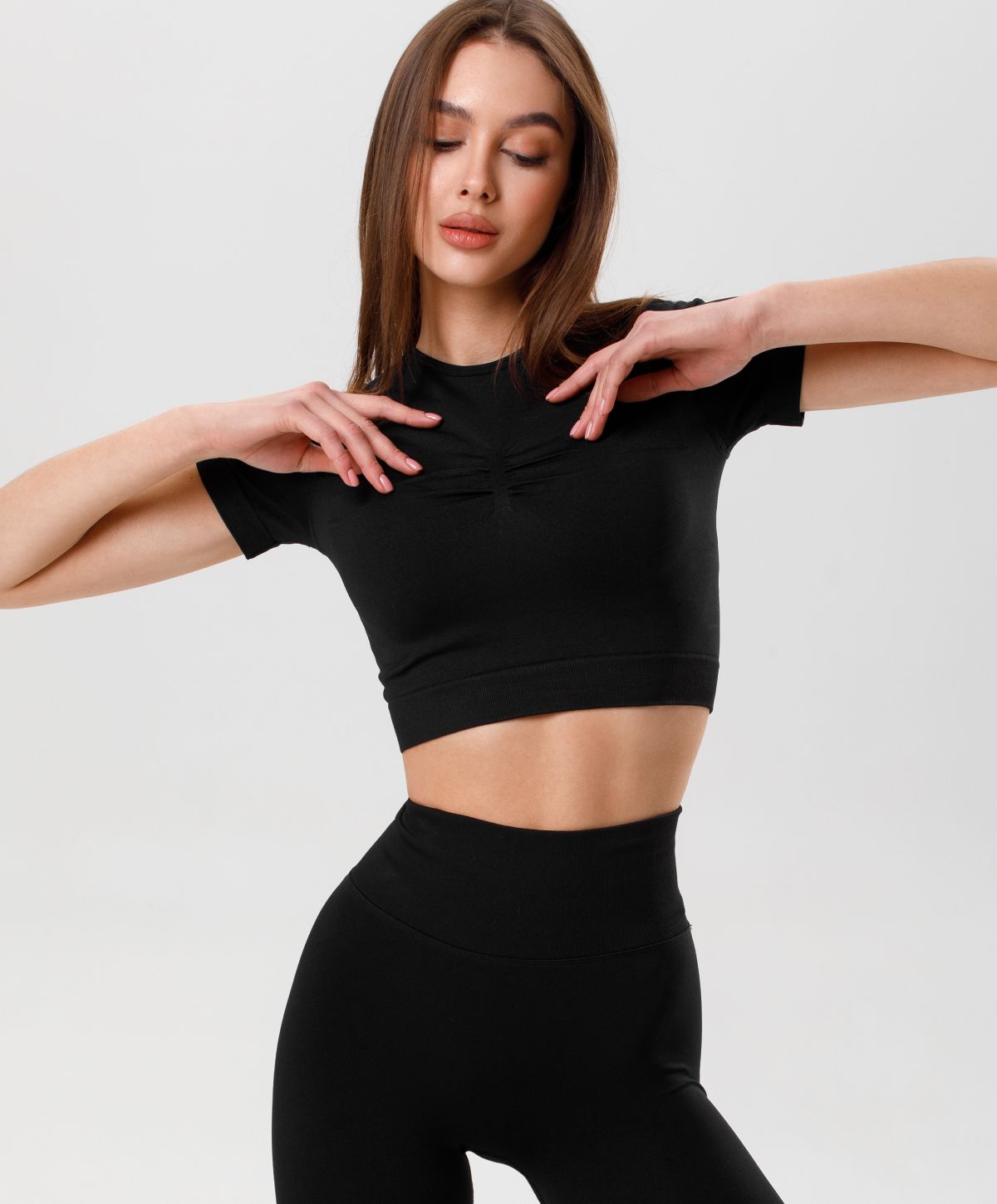 Woman in stylish black athletic outfit posing gracefully.