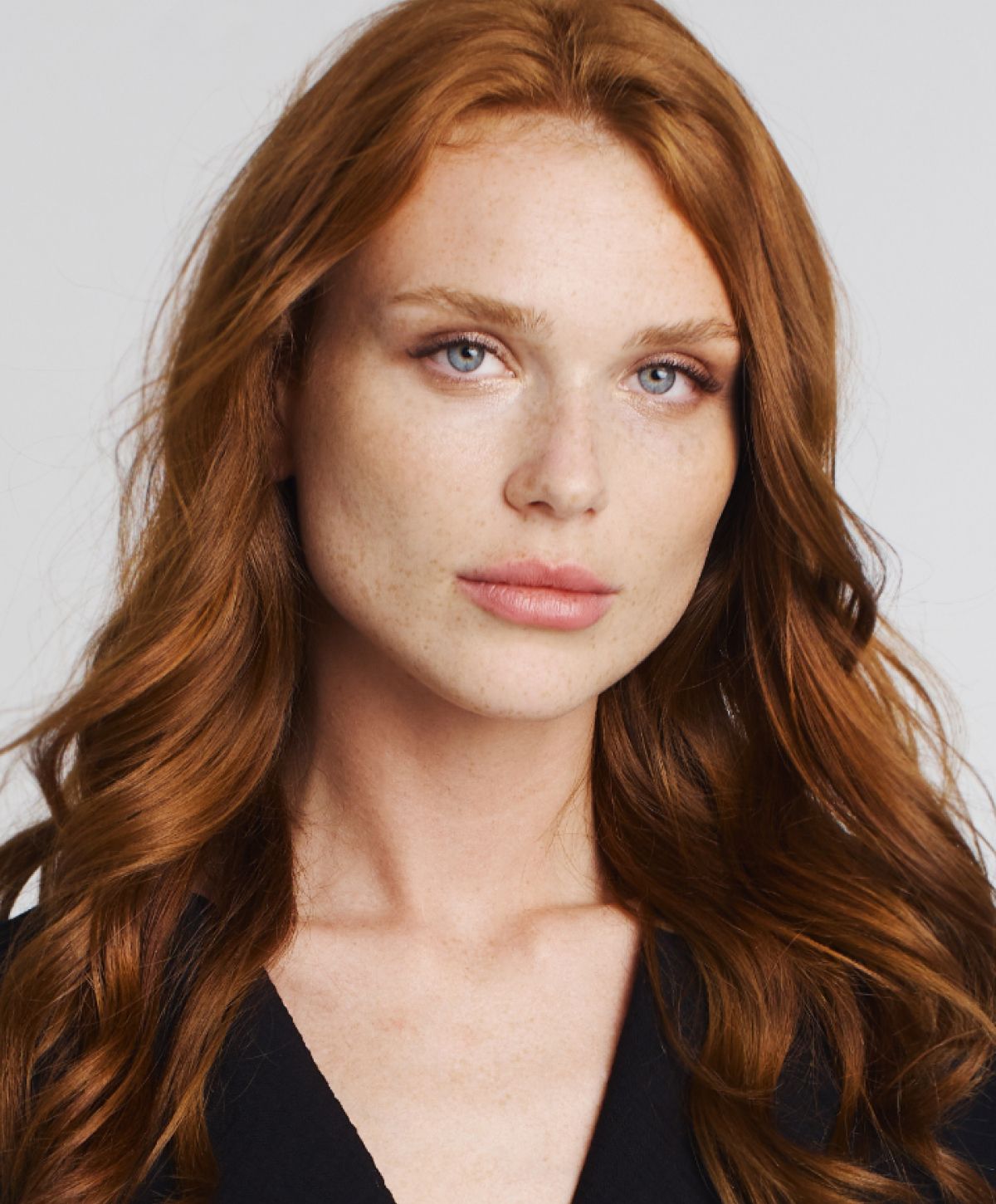 Model with wavy red hair and freckles.