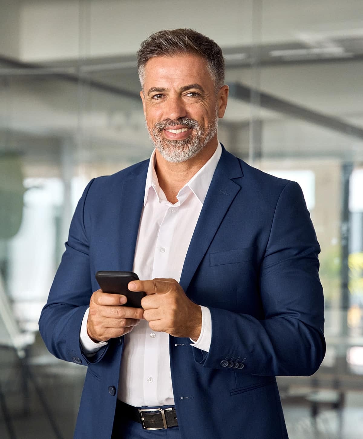 Professional man texting in a modern office.
