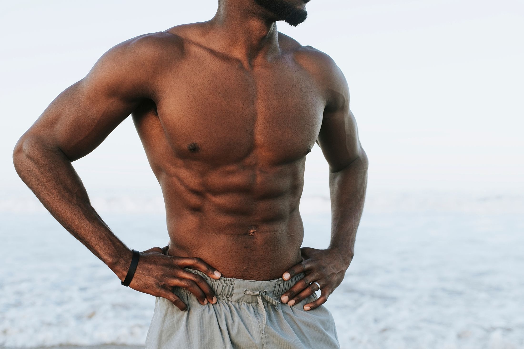 Muscular man standing at the beach.